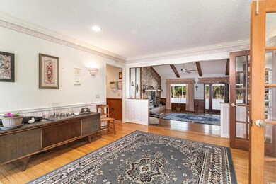 Foyer entrance featuring hardwood / wood-style floors, vaulted ceiling with beams, and french doors