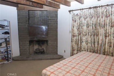 View of the Master bedroom Suite showing the fireplace.   The curtains cover a sliding glass door to the back yard.    Actually, the stage is right there as you go outside.