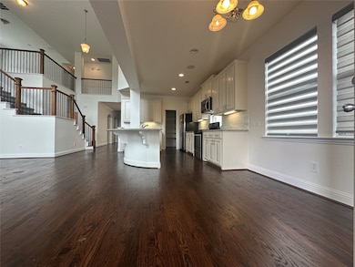 Unfurnished living room with dark wood finished floors, stairway, recessed lighting, and a chandelier