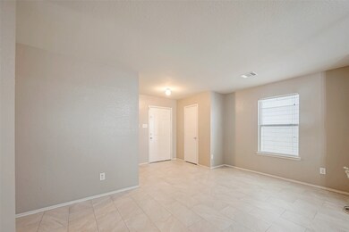 This room features a window with blinds, a ceiling light, and a white entrance door, offering a clean and inviting atmosphere.