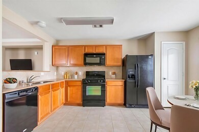 This kitchen features warm wooden cabinets, black