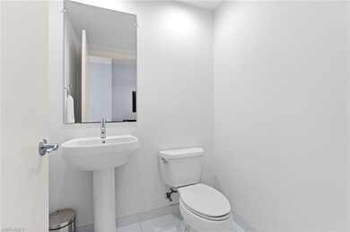 Bathroom with toilet, tile patterned floors, and baseboards