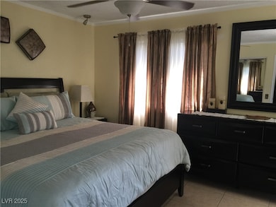 Bedroom with a ceiling fan, crown molding, and lig