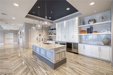 Kitchen featuring white cabinetry, tasteful backsp