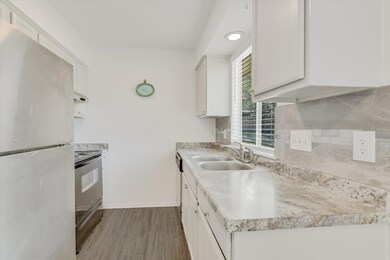 Kitchen with freestanding refrigerator, a sink, r