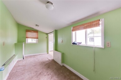 Carpeted empty room featuring vaulted ceiling