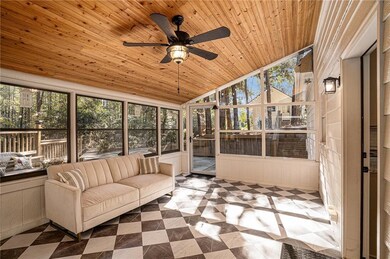Sunroom with vaulted ceiling, a ceiling fan, plenty of natural light, and an outdoor living space
