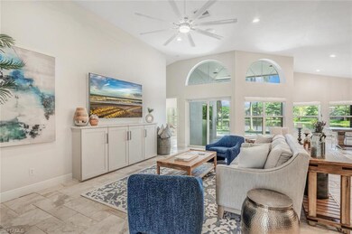 Tiled living room with ceiling fan and high vaulte