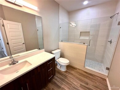 Bathroom with vanity, toilet, and a shower with shower door