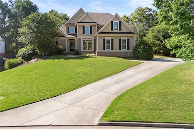 Craftsman house featuring brick siding, a front yard, concrete driveway, and a standing seam roof