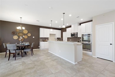 Kitchen featuring backsplash, white cabinets, a chandelier, appliances with stainless steel finishes, and recessed lighting