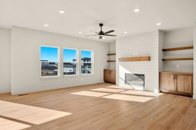 Unfurnished living room featuring a large fireplace, light wood-style flooring, recessed lighting, and a ceiling fan