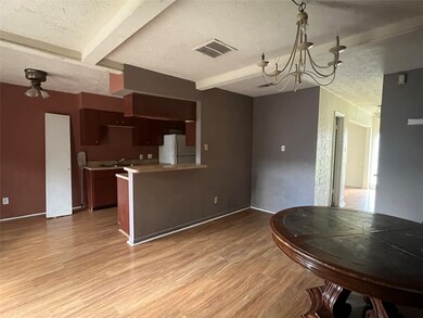 Entering the back door leads you to this dining area with a den and kitchen. To the right, you can see the front entry and living area.
