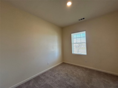 Unfurnished room with dark colored carpet and recessed lighting