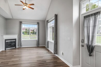 Walk in to a beautiful living room with huge windows, tons of natural light, and a gas burning fireplace