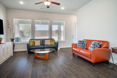 Living room with ceiling fan, plenty of natural li