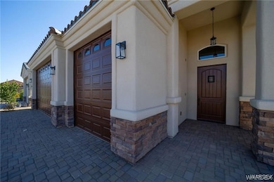 View of exterior entry with stucco siding, stone s