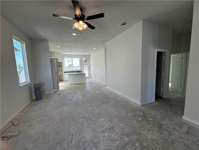 Unfurnished living room with baseboards and ceiling fan