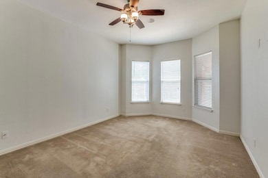 Empty room featuring ceiling fan and light colored