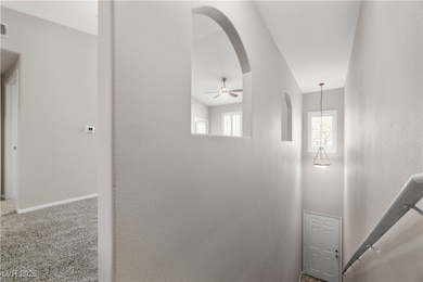 Hallway with arched walkways and carpet flooring