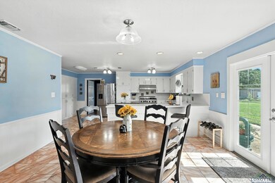 Dining area featuring ornamental molding and a wainscoted wall