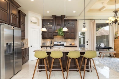 Kitchen featuring stainless steel fridge with warm stain cabinetry, crown molding, tasteful backsplash, and pendant lighting