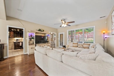 Living area featuring a ceiling fan and dark wood 