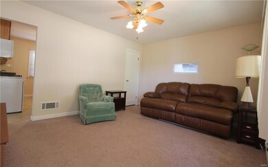 Another angle of the living room - The window on the wall is a look out into the garage. Ceiling fan and insulated vinyl windows.