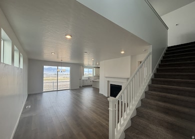 Unfurnished living room featuring recessed lighting, dark wood-type flooring, a fireplace, a chandelier, and stairs