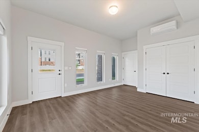 Entrance foyer featuring dark wood finished floors and a wall unit AC