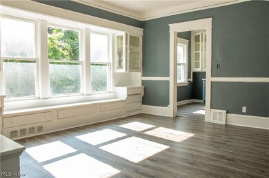 Empty room featuring dark hardwood / wood-style floors, a healthy amount of sunlight, and crown molding