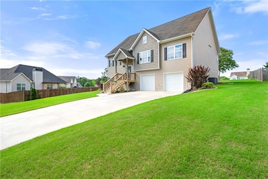 View of front of property with concrete driveway, a garage, and central AC unit