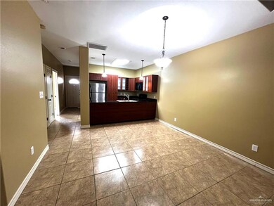 Kitchen featuring freestanding refrigerator, dark countertops, black microwave, a peninsula, and a sink