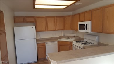 Kitchen with white appliances, a sink, light count