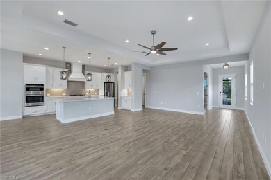 Unfurnished living room with ceiling fan, sink, a 