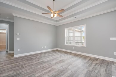 Spare room with hardwood / wood-style flooring, plenty of natural light, ornamental molding, and ceiling fan