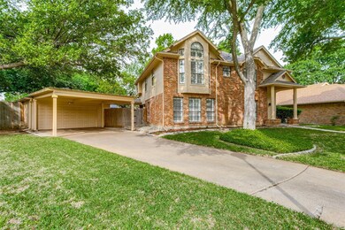 View of front of house with a carport, a garage, and a front lawn