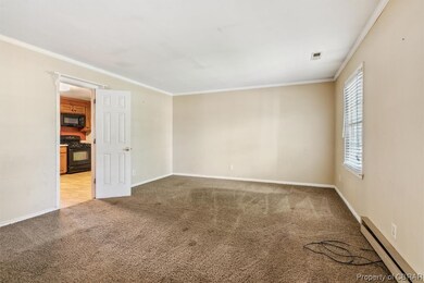 Empty room featuring a baseboard radiator, ornamen