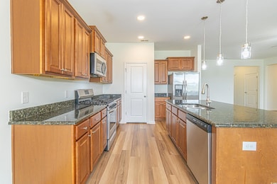 Kitchen featuring brown cabinetry, appliances with