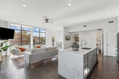 Kitchen featuring ceiling fan, an island with sink