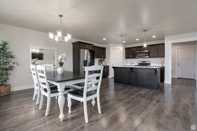 Dining space with recessed lighting, baseboards, a notable chandelier, and dark wood finished floors