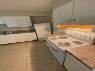 Kitchen featuring white appliances, white cabinets