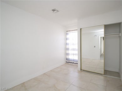 Unfurnished bedroom with visible vents, baseboards, light tile patterned floors, and a closet