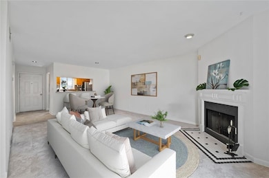 Virtually staged. Open concept, sunny, spacious living area perfect for dining room and living area nestled around the fireplace.