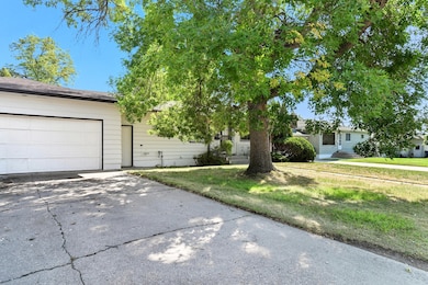 Obstructed view of property featuring concrete driveway, a front yard, and an attached garage