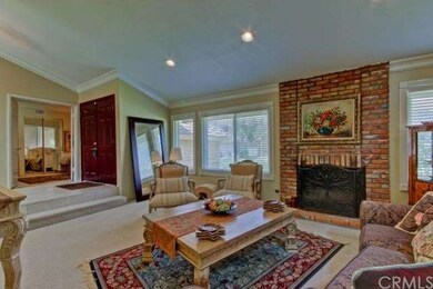 living room with brick fireplace off entry way