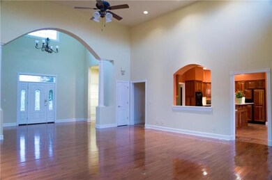 A view toward the arched entry with built in shelving and the pass through window from the kitchen create a desirable open living environment! 