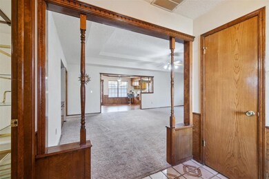 Entrance foyer with light carpet and ceiling fan