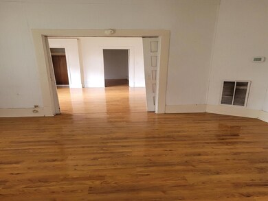 Living area featuring hardwood and the transition into primary bedroom.