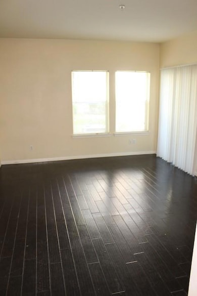 Unfurnished room with dark wood-style flooring an